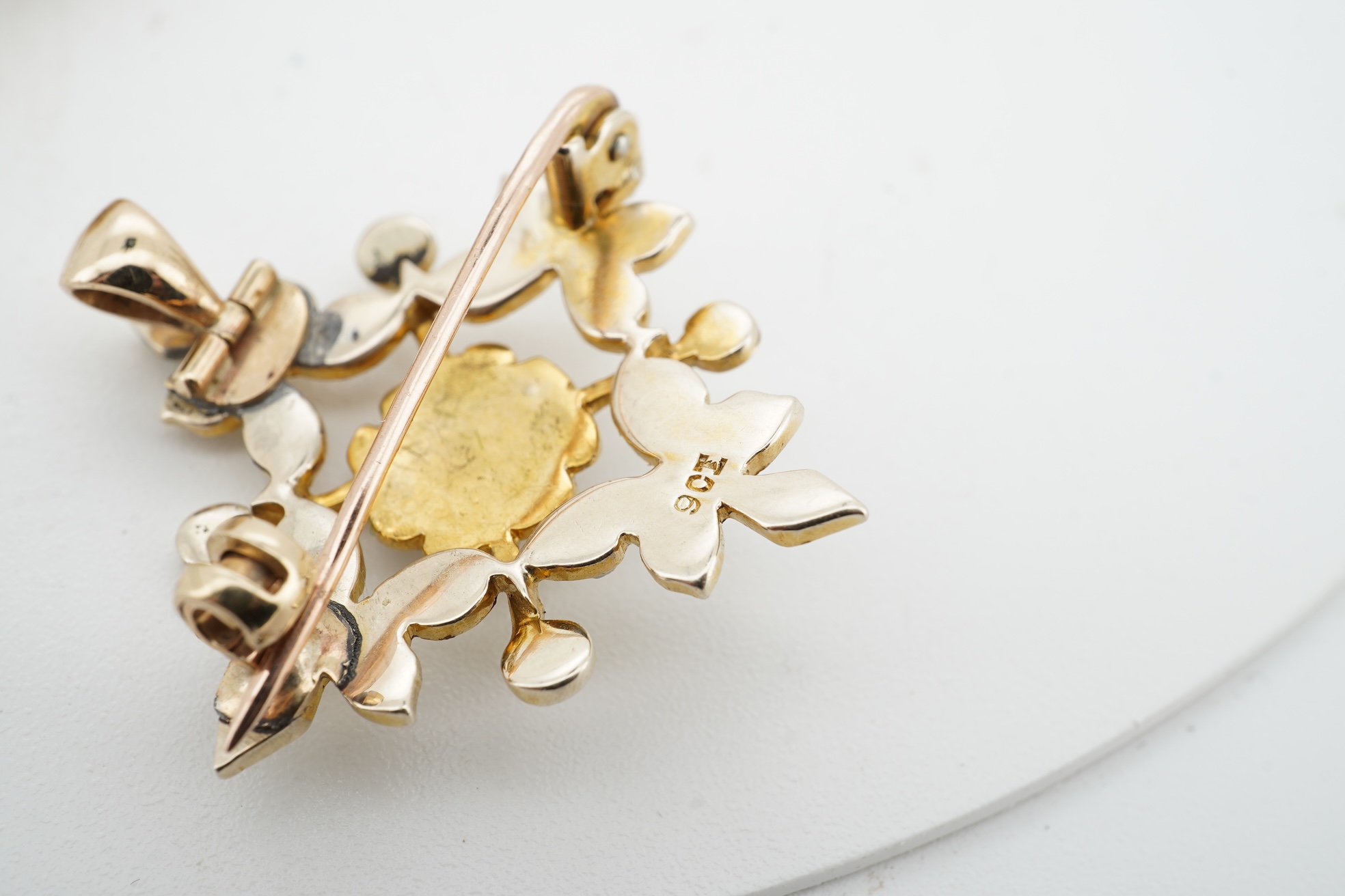 Three brooches, comprising: a Victorian circular brooch centring on a cabochon onyx set with a rose-cut diamond in a star setting, to concentring bands of seed pearls and Greek key motifs in black enamel, the reverse wit